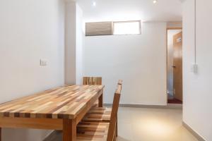 麦德林CASA TURISTICA MACHU PICCHU MEDELLIN的一间带木桌和窗户的用餐室