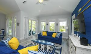 安娜玛丽亚Anna Maria Beach House, 5 beds 6,5 baths, roof-top deck and pet-friendly!的客厅配有蓝色的沙发和黄色的枕头。