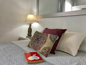 巴塞罗那Borne rooms的床上的书和枕头,带灯