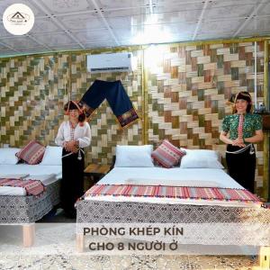 Ban Hin LomHomestay Minh Ngọc的两名妇女站在带两张床的房间