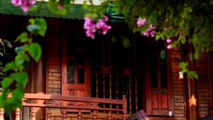 Ban Hin LomHomestay Minh Ngọc的粉红色花房前的木凳