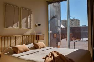 波尔图Aparthotel Oporto Anselmo的一间卧室设有一张床和一个大窗户