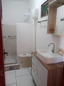 雅瓜鲁纳Apartamento a Beira Mar的白色的浴室设有水槽和卫生间。