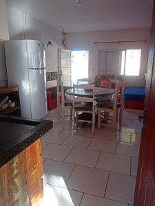 雅瓜鲁纳Apartamento a Beira Mar的厨房配有桌子和冰箱