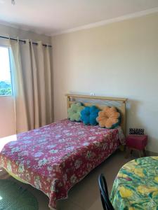皮拉西卡巴Pousada Villa Argos Guesthouse的一间卧室配有一张带彩色床罩的床
