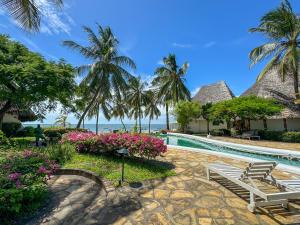 马林迪Kaleb's Beachfront Villa的一个带游泳池和棕榈树的度假村