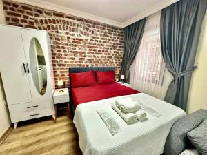 伊斯坦布尔Golden Stay Boutique Hotel Taksim的一间卧室设有红色的床和砖墙