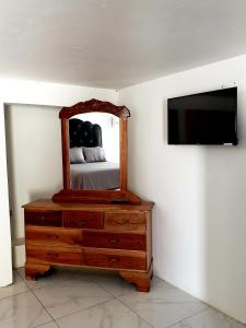 蒙特哥贝Cozy Apartment Greenwood的一间卧室配有镜子和带电视的梳妆台