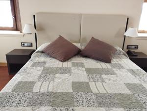 Maya del BaztánHotel Jauregi Borda的一间卧室配有一张带两个枕头和两个灯的床。