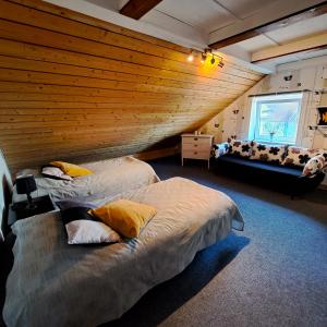 LinderödUnique rustic property in skåne的木墙客房的两张床