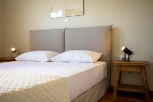 爱琴娜岛Oinopia Apartments的一张带两个枕头的床和一张桌子上的台灯