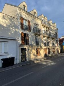 马恩河畔维列Beau studio cosy entre Paris et Disneyland的街道边的白色大建筑