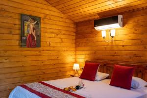 KoycegizEden Bungalows and Beach的一间带木墙的卧室和两张带红色枕头的床