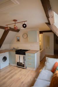 布里奇诺斯Countryside Loft in Bridgnorth的一间带炉灶的厨房和一张沙发