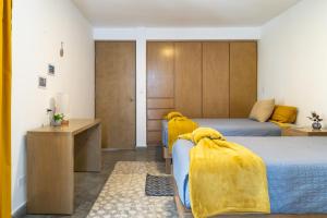 拉巴斯CASa SENECA的一间卧室配有两张带黄色毯子的床