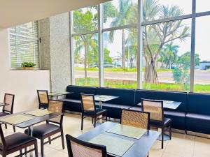 巴西利亚娜鸿酒店的餐厅设有桌椅和窗户。