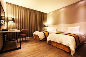 朴子山海大饭店的酒店客房配有两张床和一张书桌