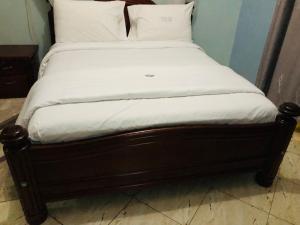 卡巴莱Gorilla Homestay Kabale的一张带白色床单和枕头的床