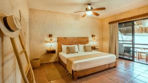 普拉亚卡门考利布里海滩酒店的一间卧室配有一张床和吊扇