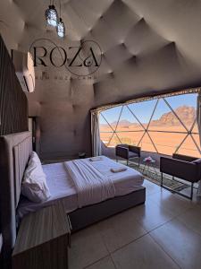 瓦迪拉姆Rum Roza luxury camp的一间卧室设有一张床和一个大窗户
