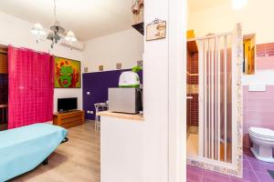 QuattromiglioGuestHouse Pet's Friendly的一间设有粉红色和紫色墙壁的客房和一间浴室