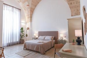 纳尔多地中海公寓式酒店的一间卧室配有一张床、一张桌子和一张书桌