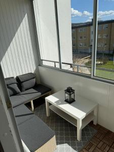 延雪平Lägenhet Elmia的小阳台配有白色的桌子和沙发。