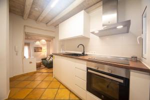 格拉纳达Apartamentos Indalo a los pies del Albaicín的厨房配有白色橱柜、水槽和炉灶。