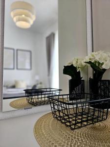 维尔Apartment Melani的一面镜子,上面有两篮子,桌子上放着鲜花