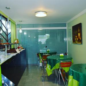 马卡埃Hospedagem Belo Horizonte的一间餐厅,房间内设有绿色的桌椅