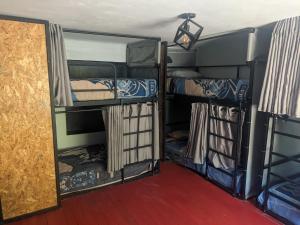 皮萨克Aguaymanto pisac hostel的带三张双层床和门廊的客房