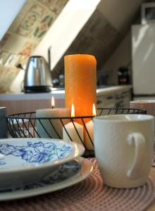 格但斯克Przytulne Poddasze w Gdańsku的蜡烛和盘子,桌子上一杯