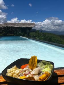 塔拉波托El Resort de Yanashpa - Tarapoto的在游泳池前吃一碗食物