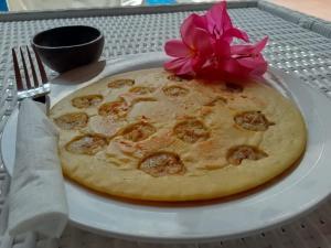 吉利特拉旺安Lumiere Hotel Gili Trawangan的盘子上的比萨饼,上面有花