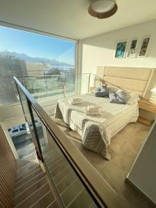 乌斯怀亚Miras Apartment Ushuaia的一间卧室设有一张床和一个玻璃阳台