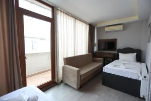 伊斯坦布尔欢呼灯塔酒店的卧室配有床、椅子和窗户。