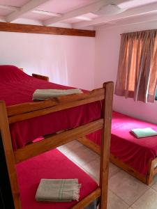 埃博森Camping El Bolson的一间卧室配有两张双层床,铺有红色床单