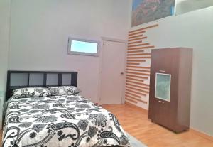 圣塞巴斯蒂安德洛斯雷耶斯Loft con baño y cocina privados的一间卧室配有床、橱柜和窗户