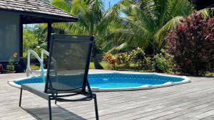 乌图罗阿RAIATEA - Orion Pool Bungalow的游泳池旁甲板上的椅子