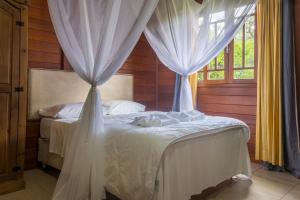 坎博里乌Fazenda dos Caetés的卧室配有2张带白色窗帘的床
