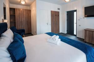 奥拉迪亚ALIVE HOTEL的卧室配有一张白色大床和两条毛巾