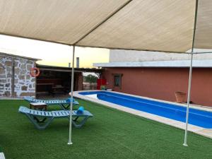 圣米格尔德阿沃纳Casa Rural Tamaide的一个带两把椅子的庭院和一个游泳池