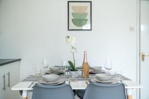 吉尔福德Prime Living的一张带蓝色椅子的餐桌和一瓶葡萄酒