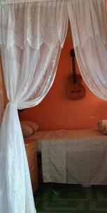 Kapeta Cabin的一间卧室配有一张带白色窗帘的床