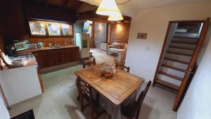 圣马丁德洛斯La casita de Maichu的厨房以及带木桌的用餐室。