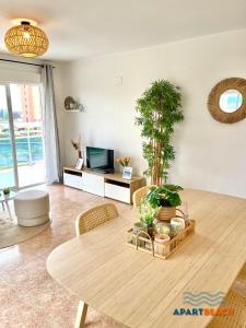 拉皮内达APARTBEACH LOS JUNCOS 2 RESIDENCIAL y JUNTO PLAYA的客厅配有桌子和电视