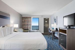 诺福克最佳西方假日沙滩旅馆和套房的配有一张床和一台平面电视的酒店客房