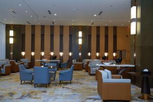艾卜哈Best Western Plus Danat Almansak Hotel的酒店大堂设有餐厅,配有桌椅