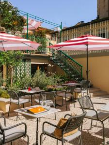 佛罗伦萨The Sonetto powered by Sonder的一个带桌椅和遮阳伞的户外庭院。