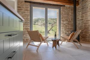 Cellino AttanasioB&B Panfilo Farmhouse的一个带两把椅子和大窗户的厨房